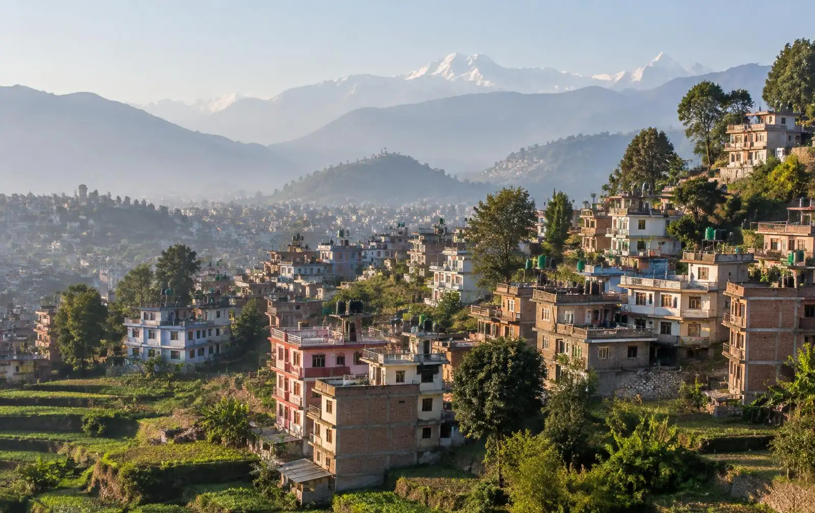 Houses on a hillside in the Kathmandu valley with the Himalaya behind